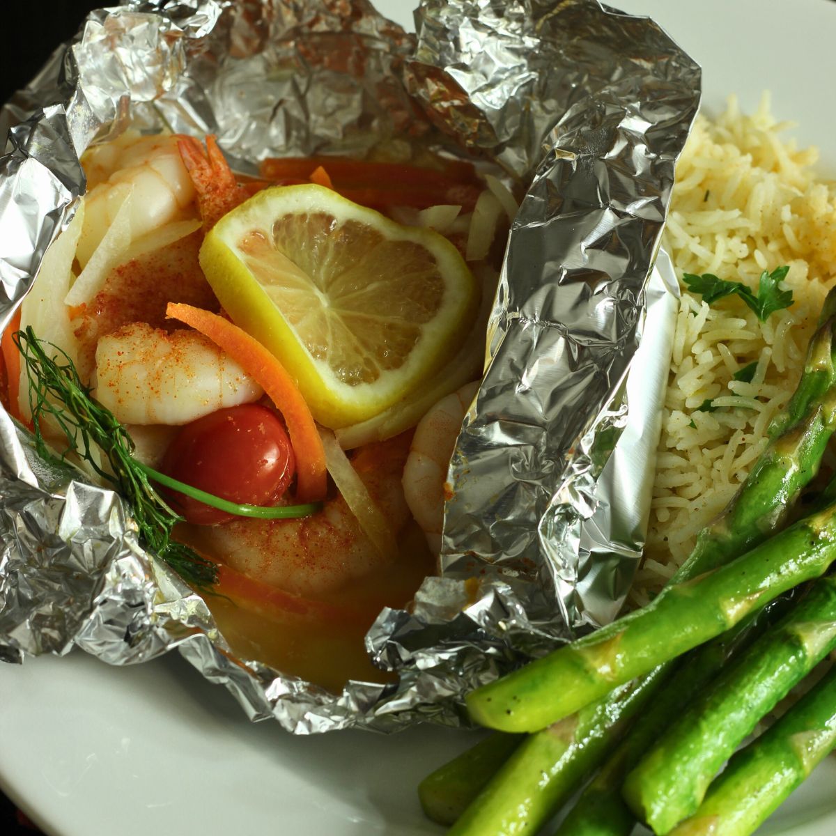 open foil packet with fish and shrimp on a plate.