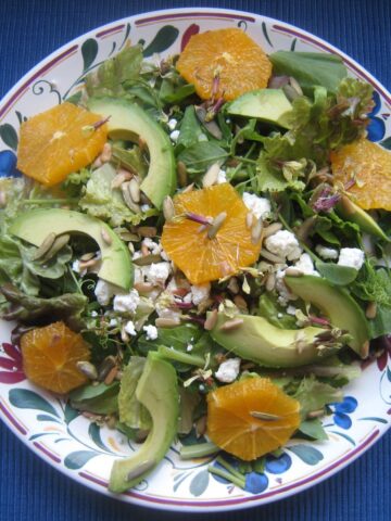 avocado and orange salad on blue counter.
