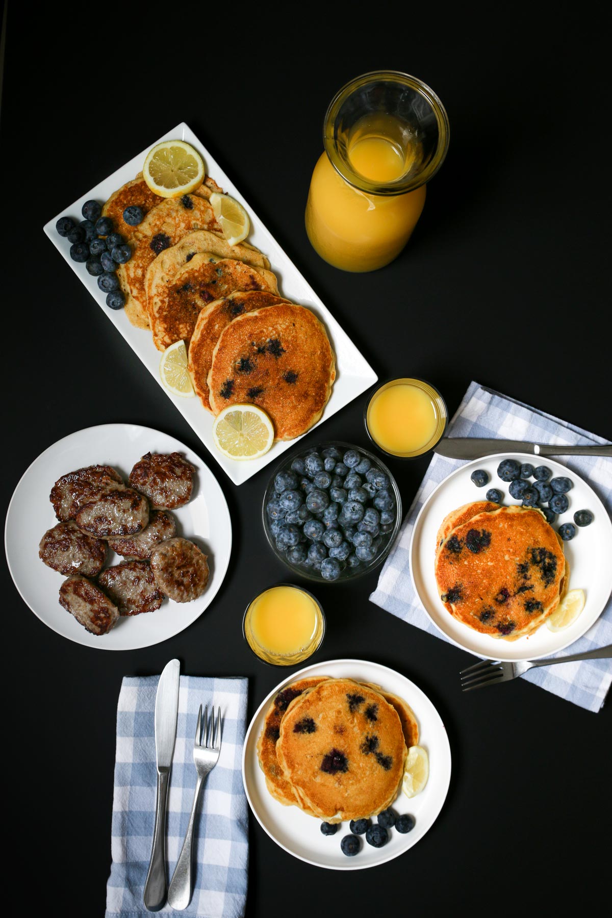 table set with platters of sausages and pancakes for dinner.