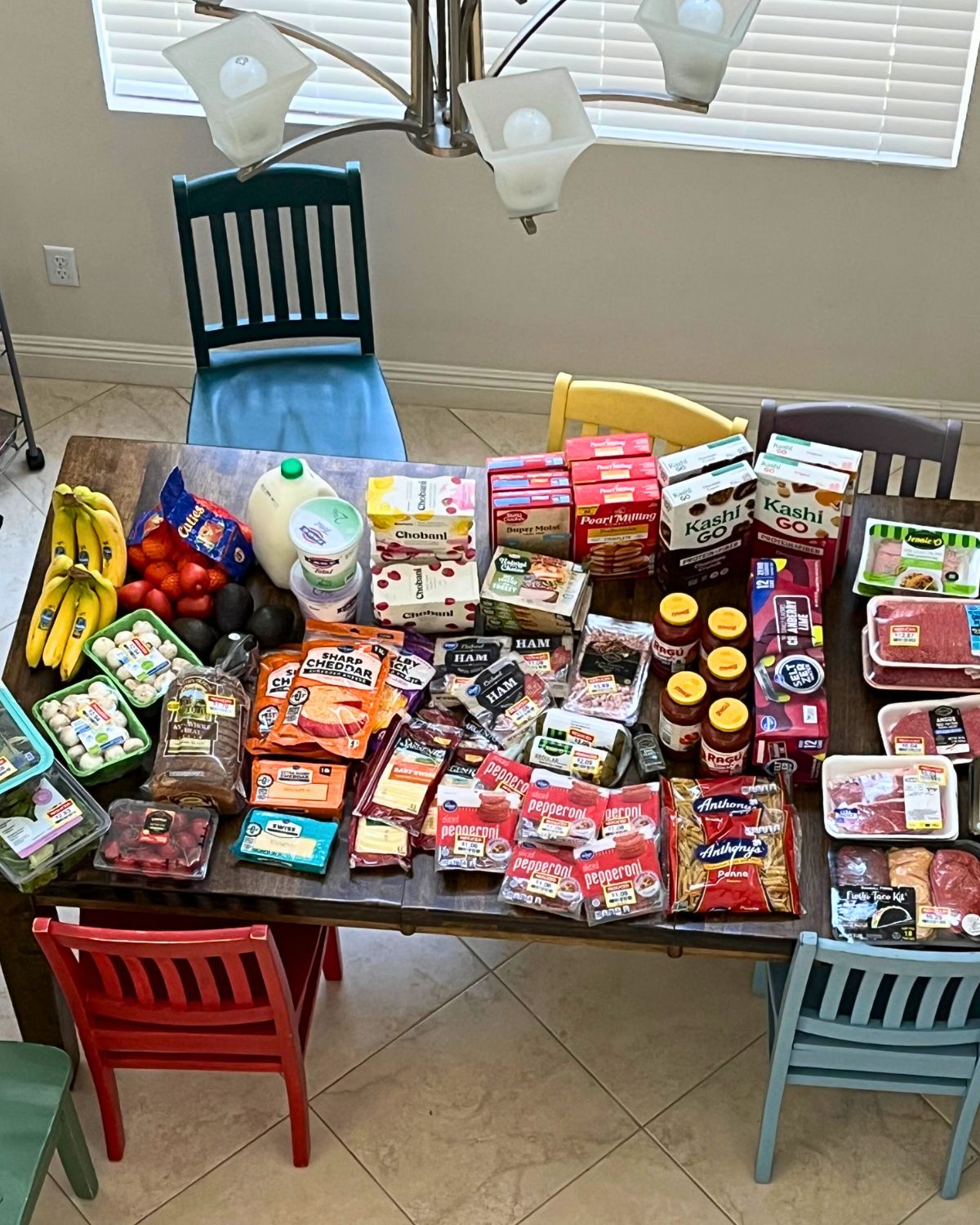groceries laid out on a table, with multiples of several items and many clearance items with tags.