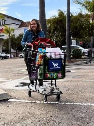 jessica pushing grocery cart in parking lot.