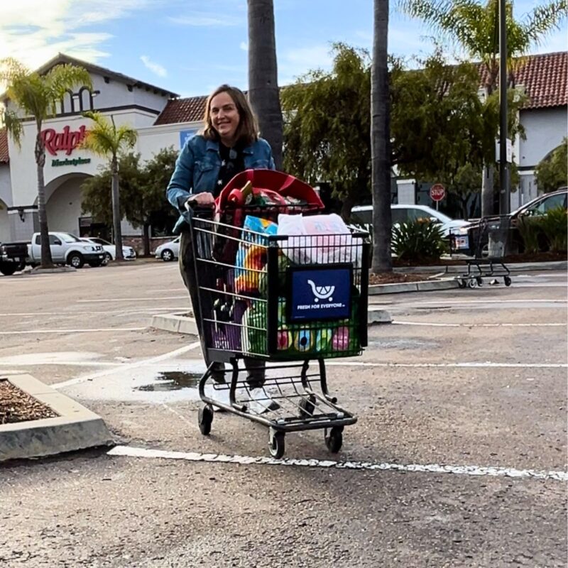 jessica pushing grocery cart in parking lot.