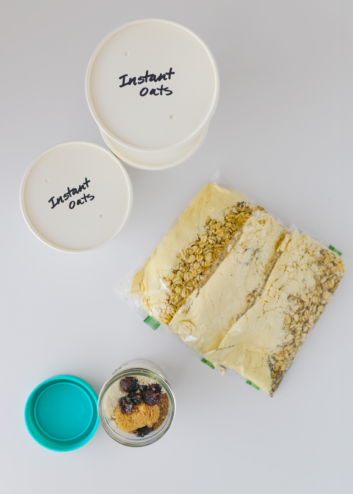 homemade instant oatmeal packets and bowls laid out on a white surface.