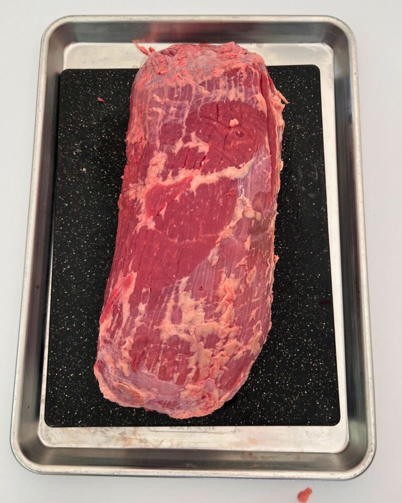 trimmed roast on cutting board inside sheet pan.