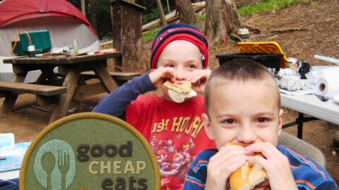 boys eating while camping with overlay of camping badge.