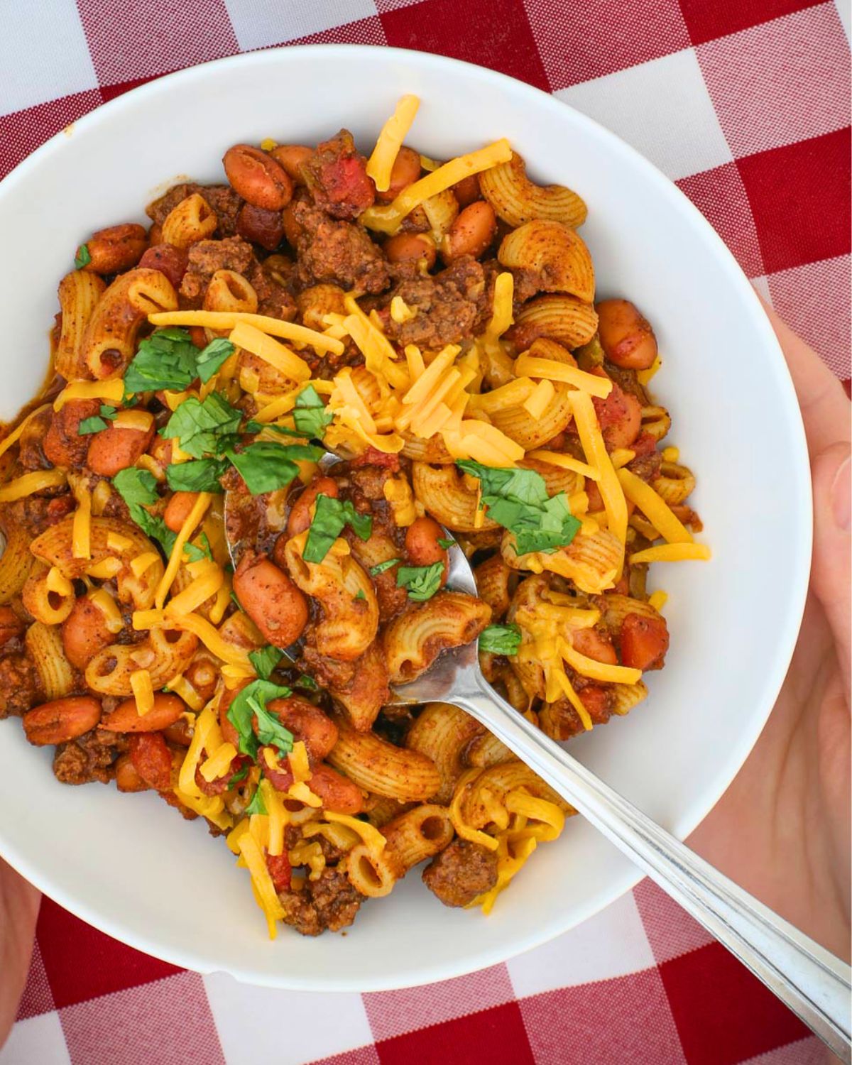 bowl of chili mac on checked cloth.