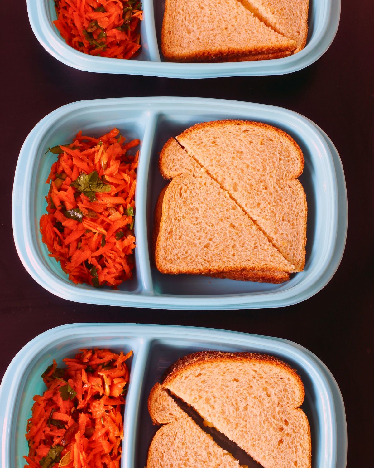 sandwiches and salads in meal prep boxes.