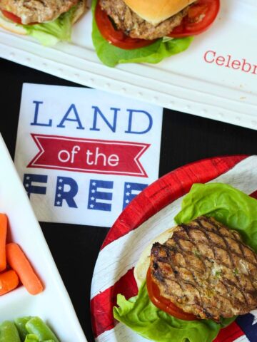 land of the free napkin with burgers and veggie tray.