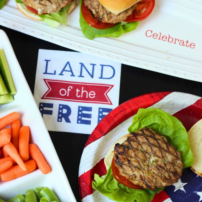 land of the free napkin with burgers and veggie tray.