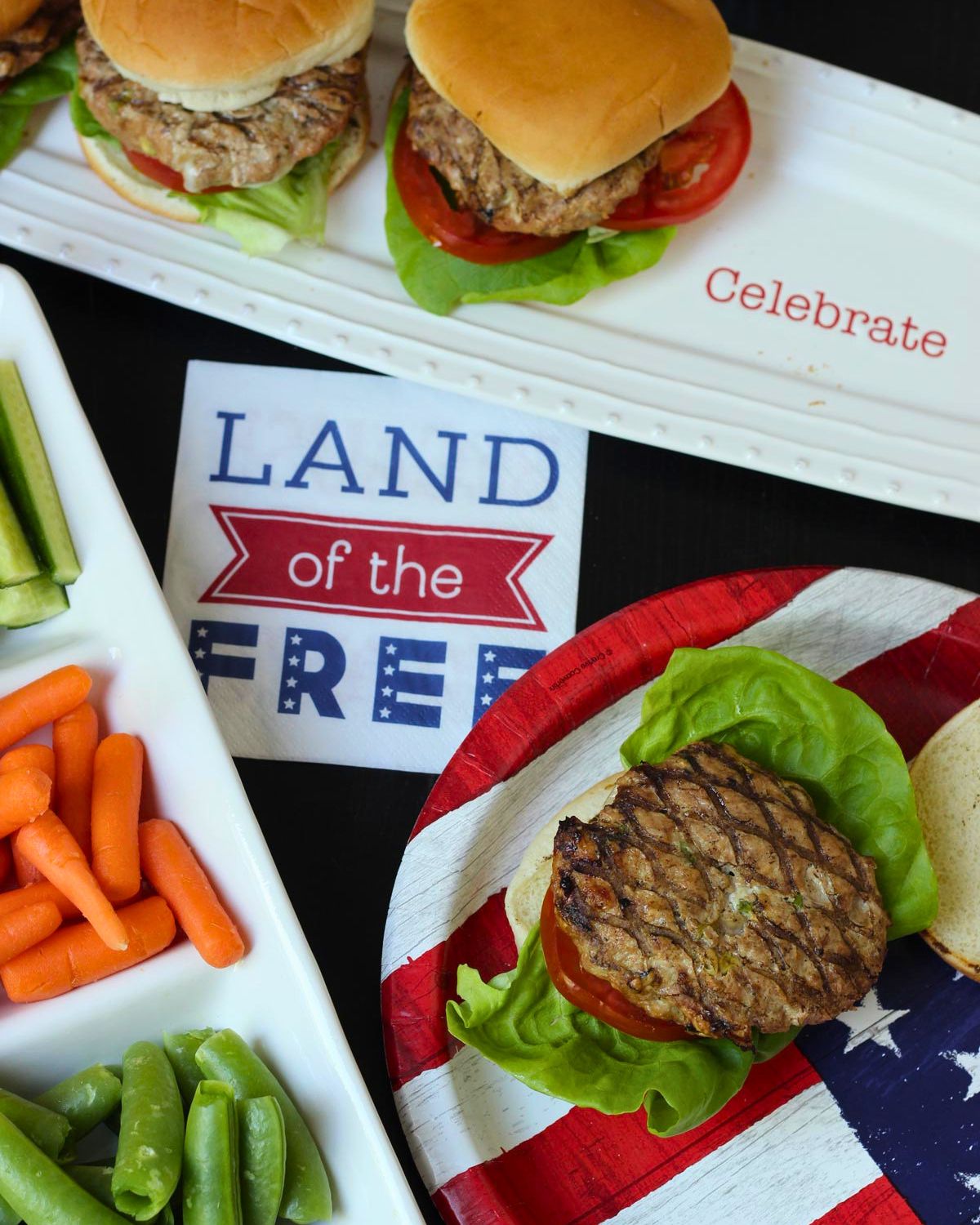 array of burgers and sides with patriotic tableware.