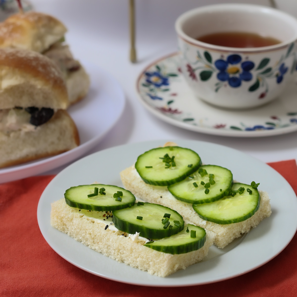 cucumber sandwiches on plate with teacup on saucer in background.