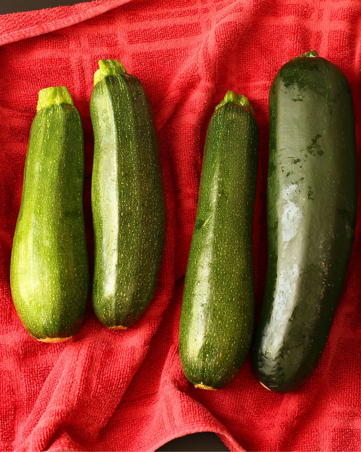 zucchini laid out on a red towel.