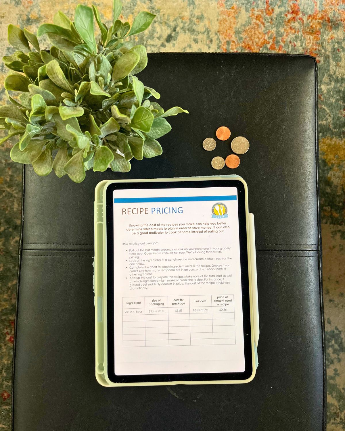 worksheet for pricing out a recipe on iPad on table top with plant and coins.