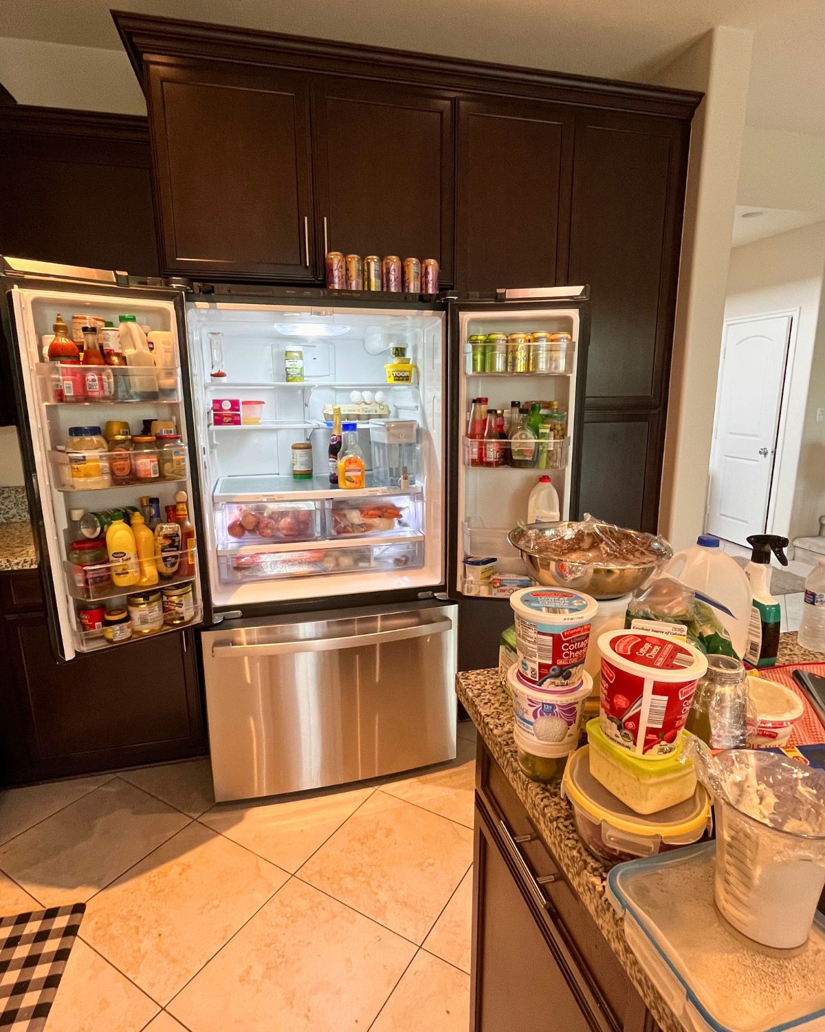 french door refrigerator with doors open and food on counter.