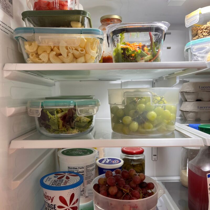clear containers of food on shelves of refrigerator.