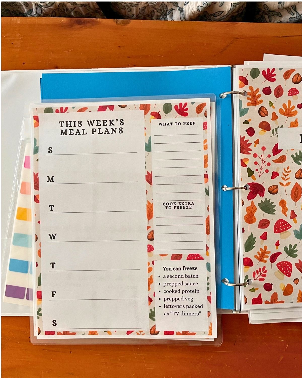 fall meal planning notebook open with a laminated copy of this week's meals on top.